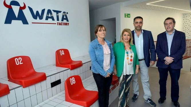 Equipo de negocios posando en el área de recepción de la oficina moderna con asientos con marca