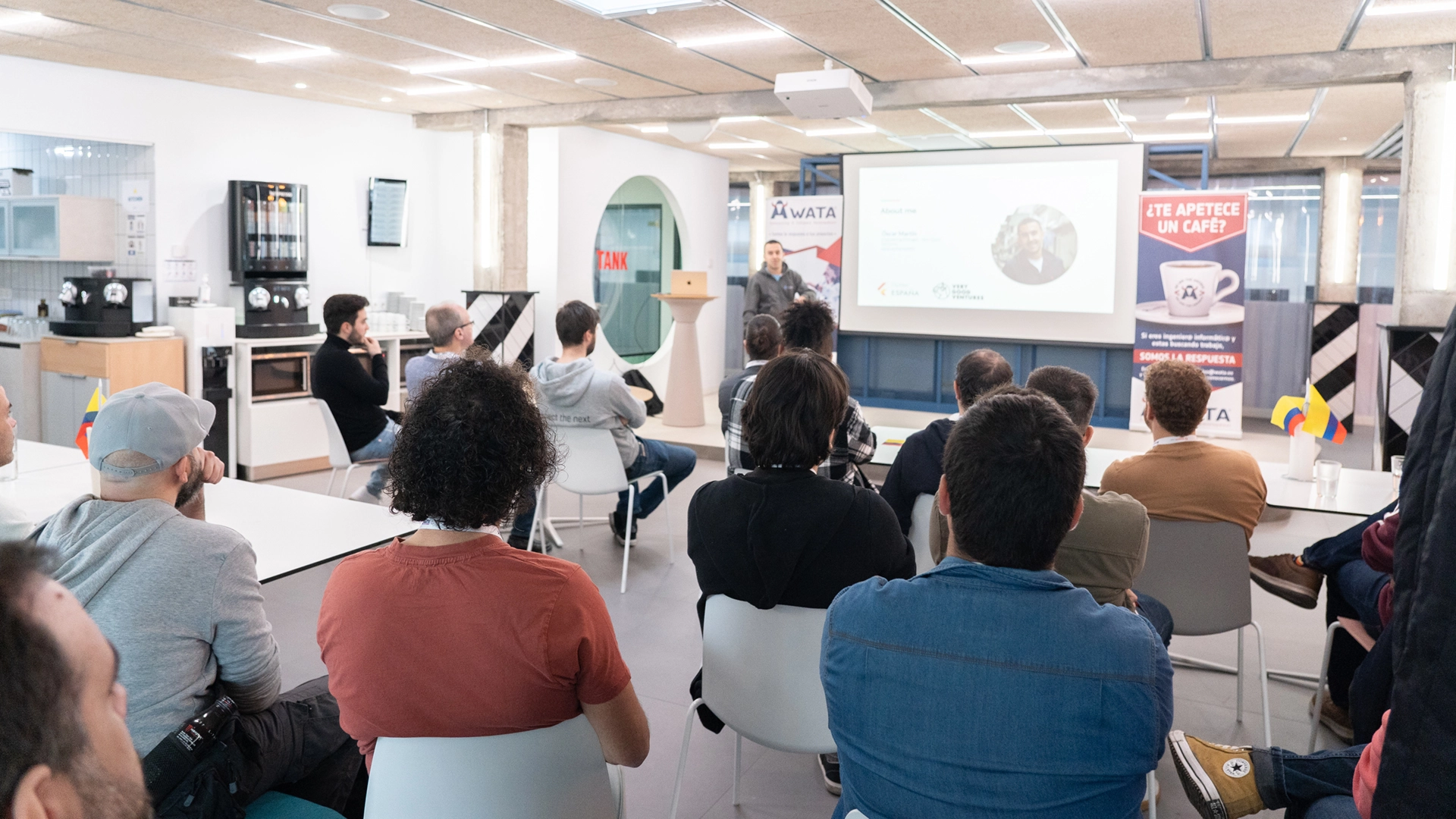 Referent spricht vor Publikum in Reihen bei Büropräsentation