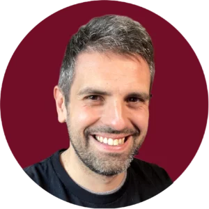 Professionelles Porträt von Carlos Azaustre, JavaScript-Experte und Autor, lächelnd vor rotem Corporate-Hintergrund der WATA Factory
