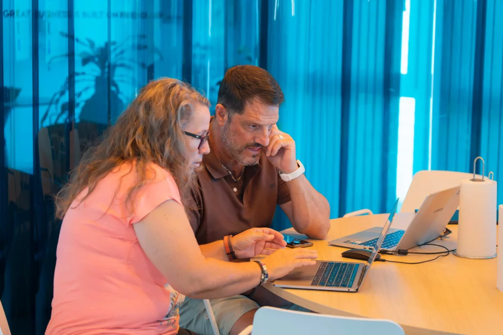 A female and a male WATA Factory employee focused on their laptops during the Kubernetes training.