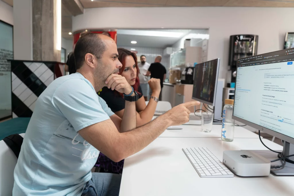 Two WATA Factory employees discussing while working on the Kubernetes practice in the workshop.