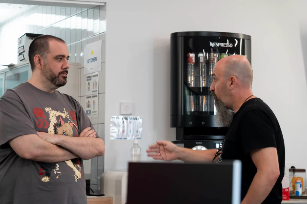 Two WATA Factory colleagues chatting animatedly at the end of the Kubernetes All Hands.