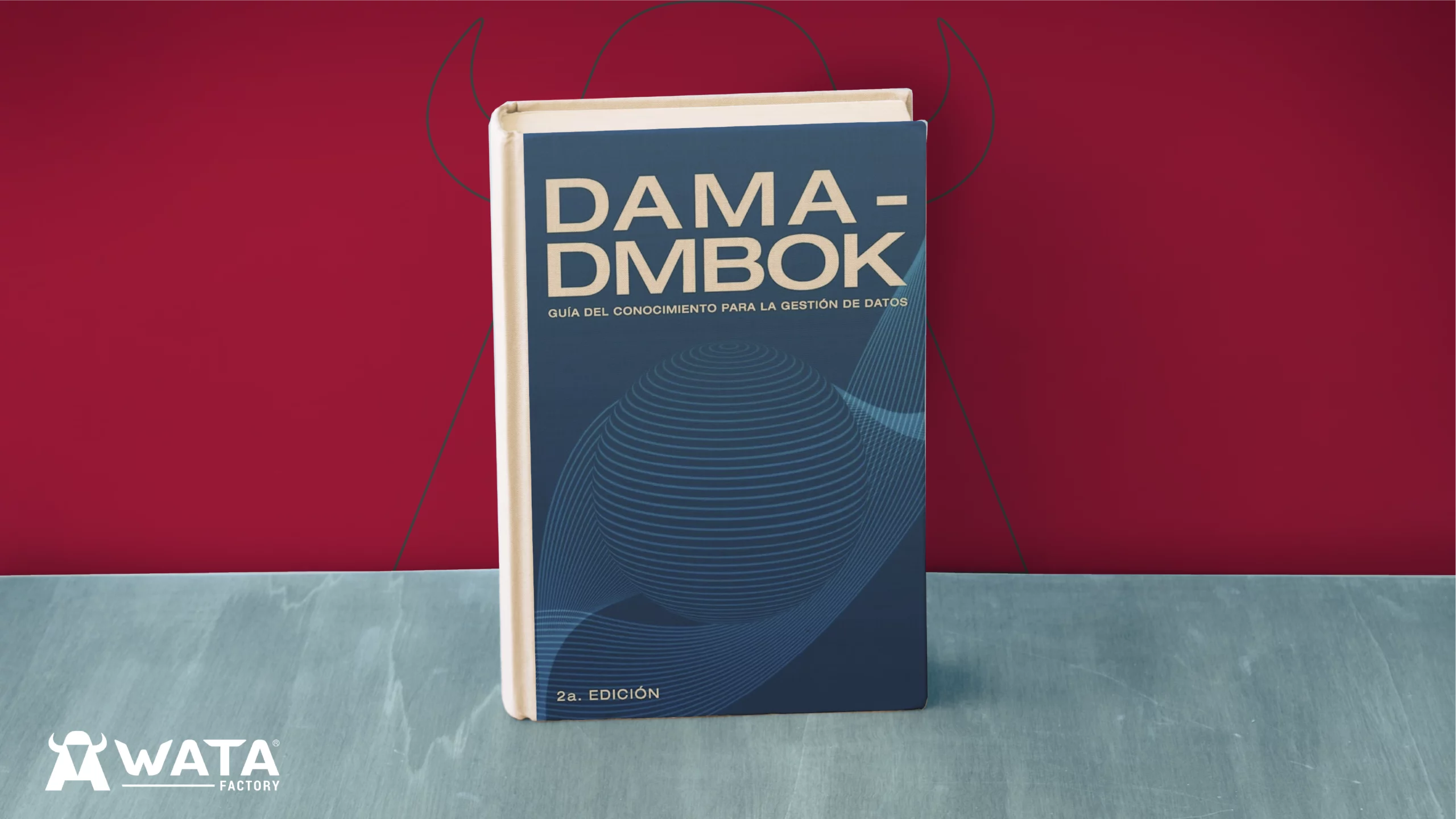 DAMA-DMBOK Buch aufrecht stehend vor einem Hintergrund mit den Unternehmensfarben von WATA Factory, das Firmenlogo sichtbar im Hintergrund.