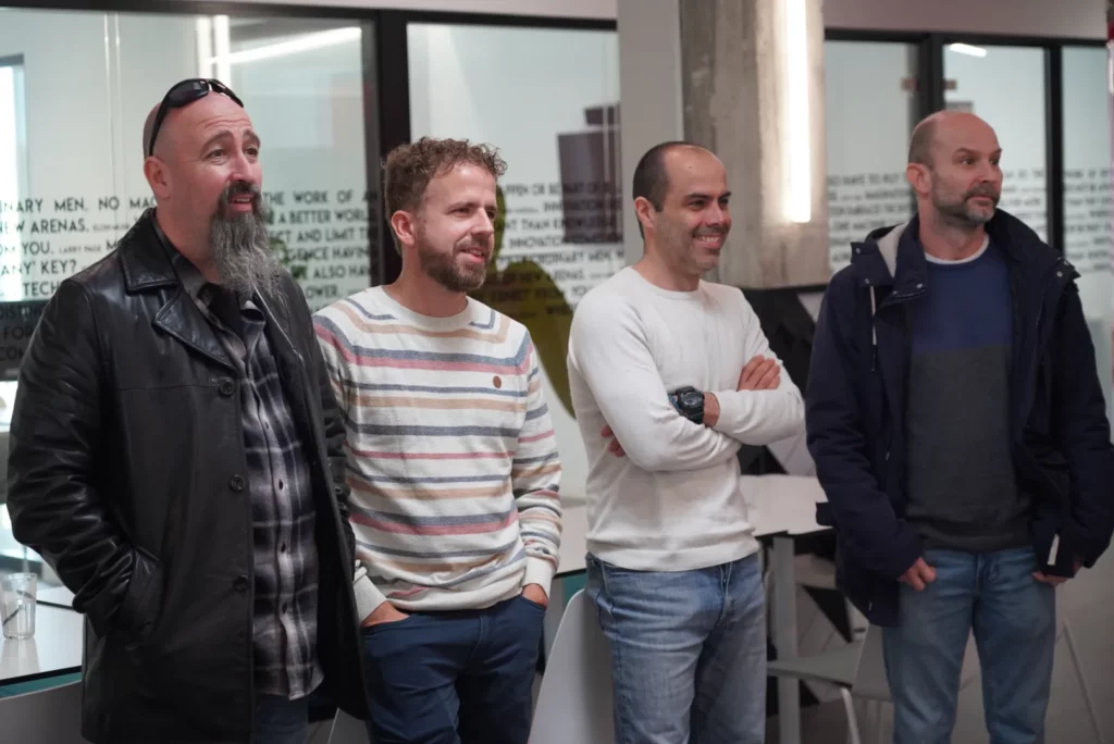 Several colleagues smiling and reacting to the personalised Christmas carol.