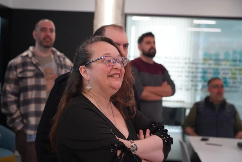 A colleague enjoying the Christmas carol with a smile during the All Hands.