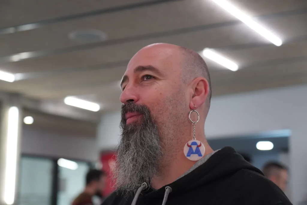 A colleague playfully placing a 3D-printed WATA Factory keychain on his ear.