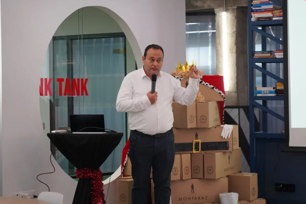 Pedro G. delivering his talk with a microphone and energetic gestures during the All Hands.