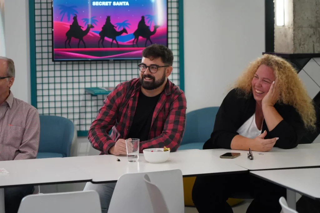 Colleagues enjoying the costume show and smiling during the All Hands.