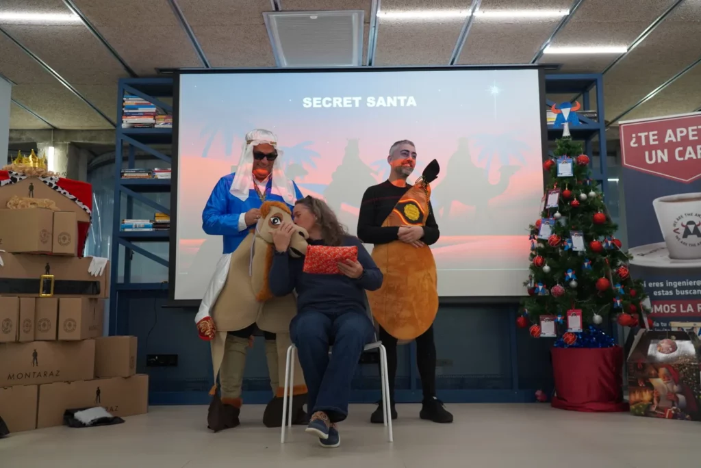 A colleague pretending to kiss the inflatable camel while receiving her Secret Santa gift.