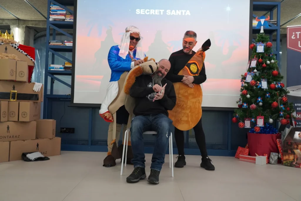 A colleague smiling while receiving a hug from the inflatable camel.