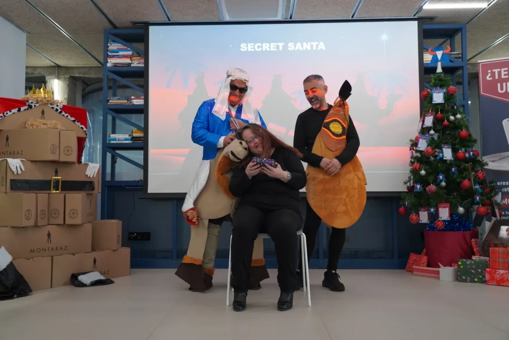 A colleague resting her head against the inflatable camel and posing playfully.