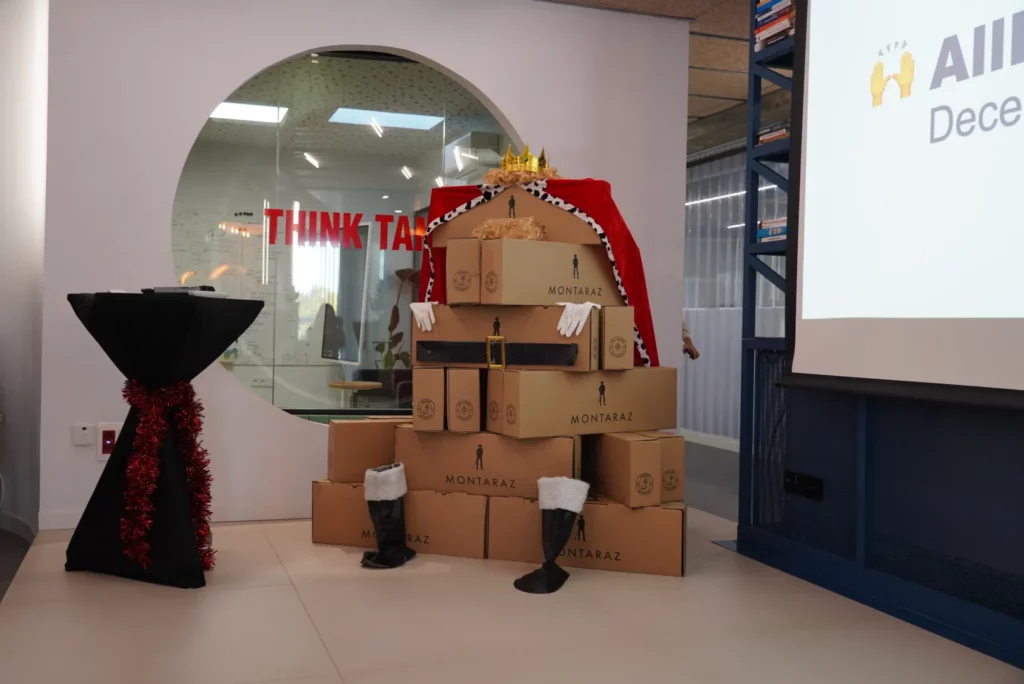 Christmas gift baskets stacked to form a decorative Wise Man figure on the All Hands stage.